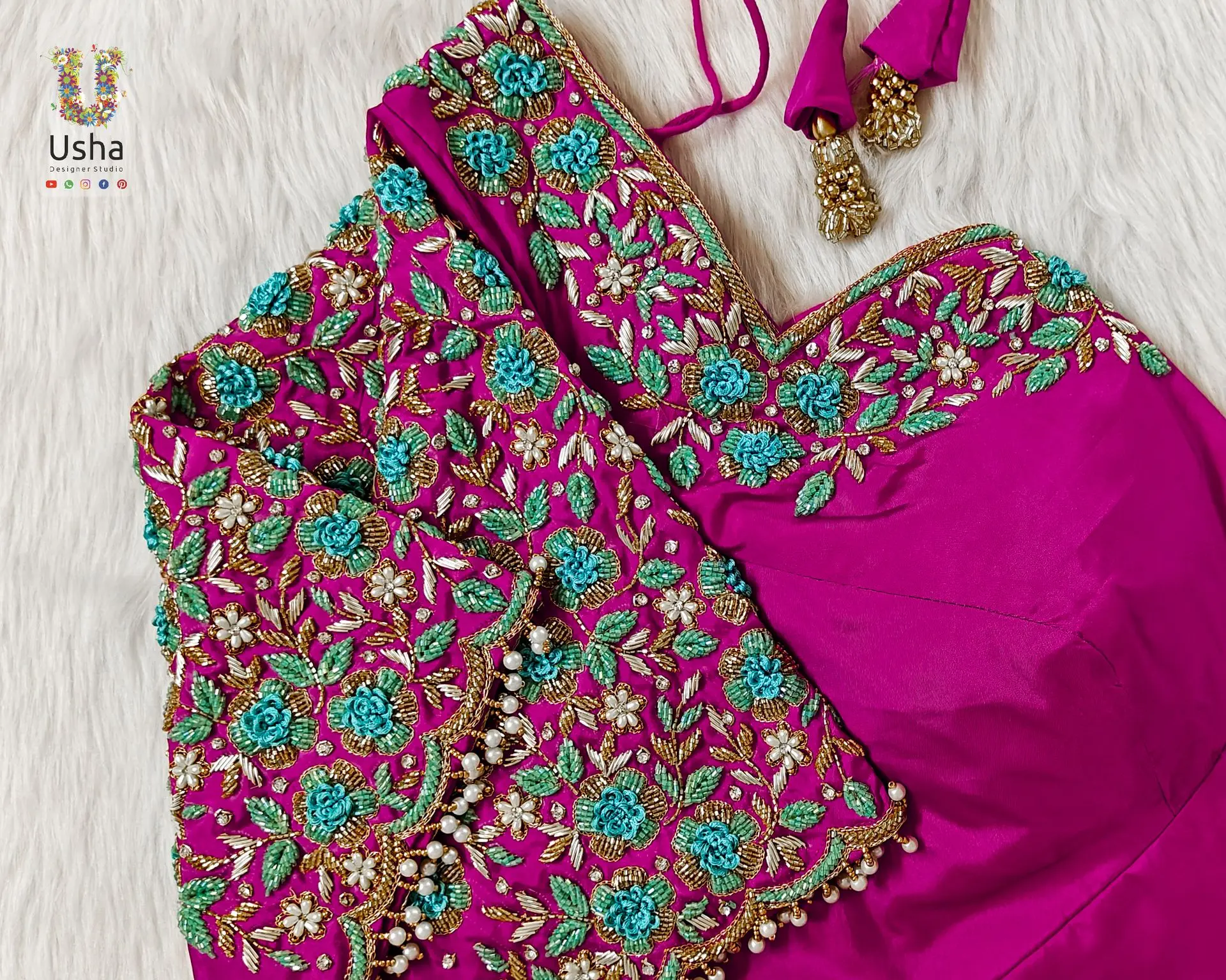 Fuchsia pink bridal blouse adorned with turquoise blue floral aari work, intricate bead detailing, and pearl drops, handcrafted by Usha Designer Studio