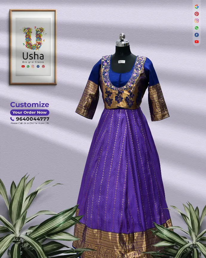 Usha Designer Studio bespoke long frock in pure pattu fabric, royal blue and deep violet, with antique gold zari border, hand-embroidered Aari floral motifs, potli ball detailing, and U-neck pattern. Saree-curated designer long dress.
