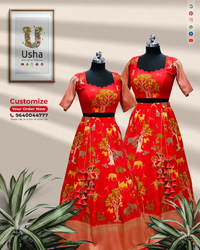 Twin red Dupion Pattu crop top lehengas by Usha Designer Studio, featuring scalloped neckline cholis adorned with intricate nature-inspired zari motifs of trees, deer, elephants, and birds. The lehengas have a bold golden zari border and handcrafted heavy latkans, radiating artisanal heritage charm—perfect for special occasions and festive celebrations.