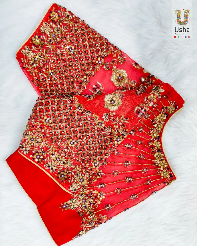 Red bridal boat neck blouse with intricate maggam hand embroidery in gold zari, beadwork, and floral lattice pattern by Usha Designer Studio, Vijayawada.