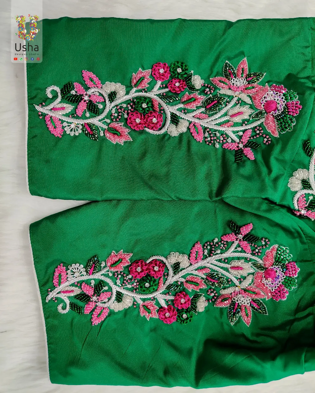 Emerald green bridal blouse with floral Aari hand embroidery in pink, white, and green threads by Usha Designer Studio Vijayawada