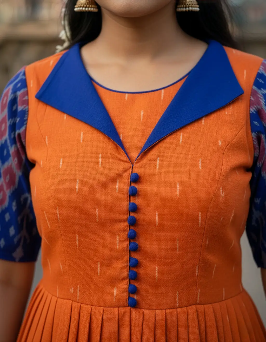 Bespoke long frock crafted from orange and blue Pochampalli saree with designer yoke, collar neck, elbow sleeves, and pleated skirt by Usha Designer Studio Vijayawada.