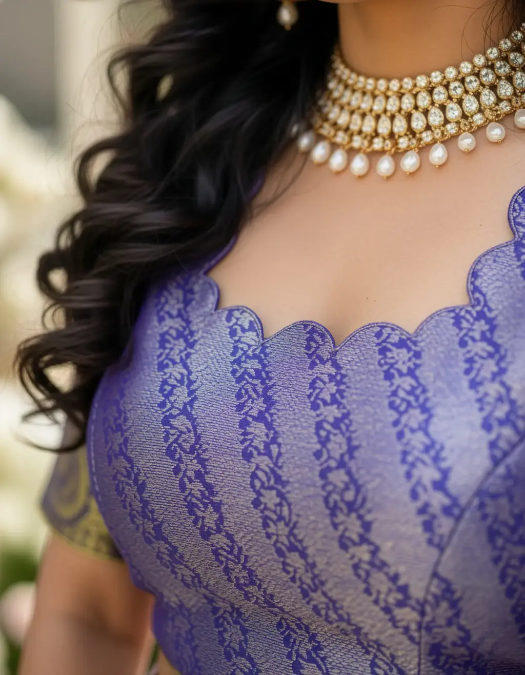 upcycled from a pure Kanchi Pattu Saree. The lehenga is pleated, in shades of lilac and gold, featuring hand-crafted blue and gold heavy latkans on the side. The matching blue and gold brocade choli blouse is visible.