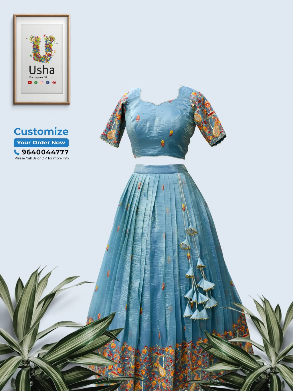 custom blue designer crop top lehenga with floral embroidery, heart neckline blouse, pleated skirt, and heavy side latkans hanging against a plain background.