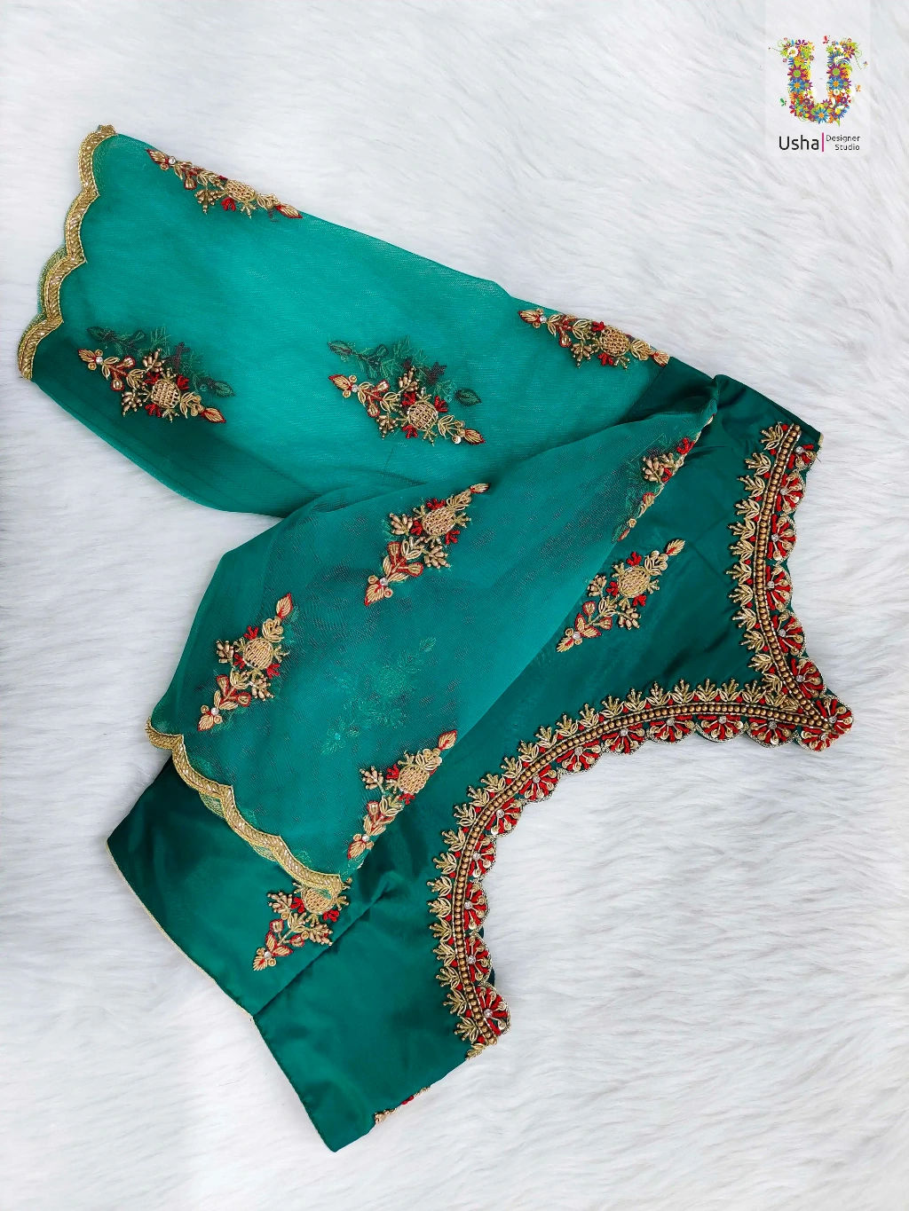 Close-up of intricate, handcrafted Aari embroidery featuring gold zari, beads, and ruby stones on rich fabric, custom-designed by Usha Designer Studio.